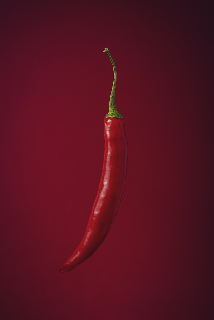 Czerwona papryczka chilli na czerwonym tle